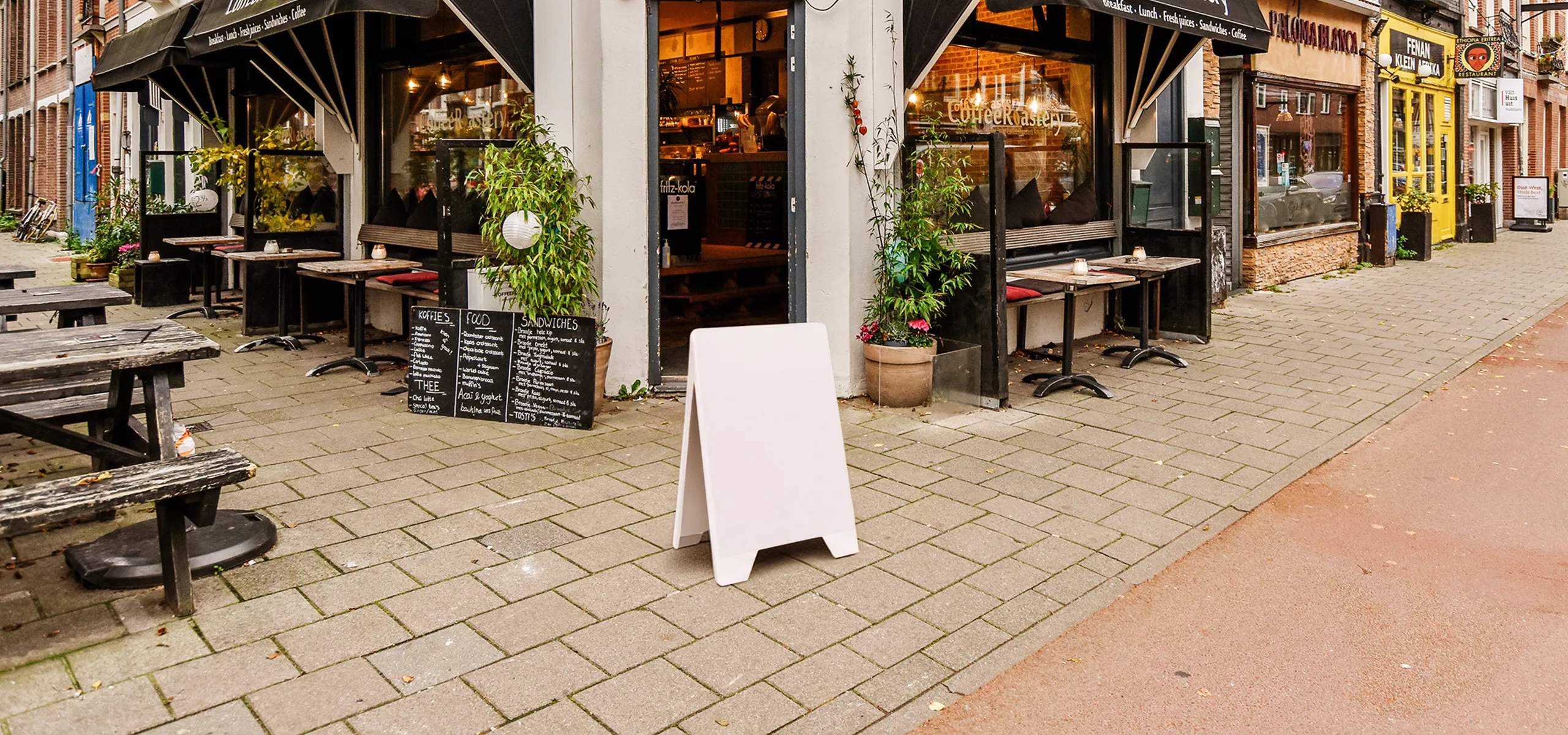 Doppelseitiger PVC-Werbeaufsteller mit Speisekarte vor einem Restaurant